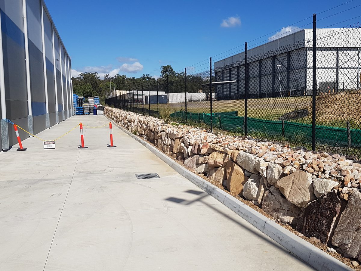 An industrial site landscape construction — paths, screening and amenity